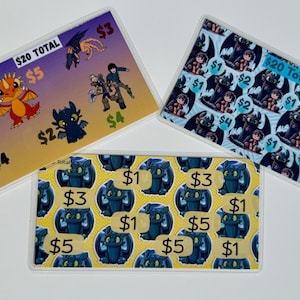 May include: Three clear plastic wallets with colorful cartoon designs. One wallet has a yellow background with blue dragons and dollar amounts. The other two wallets feature characters and dollar amounts.