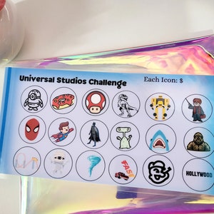 May include: A Universal Studios Challenge game card with 16 different icons, including a minion, a donut, a mushroom, a dinosaur, a transformer, Harry Potter, Spiderman, Superman, Batman, an alien, a shark, a monster, a roller coaster, a mummy, a tornado, a Fast and Furious car, a Universal Studios logo, and the word "Hollywood". Each icon is worth a dollar.
