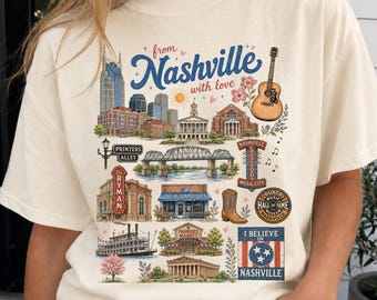 Könnte beinhalten: Ein elfenbeinfarbenes T-Shirt mit einem farbenfrohen Grafikdruck von Nashville-Wahrzeichen, darunter das Ryman Auditorium, eine Gitarre, ein Cowboystiefel und ein Raddampfer. Der Text lautet "from Nashville with love" und "I BELIEVE IN NASHVILLE".