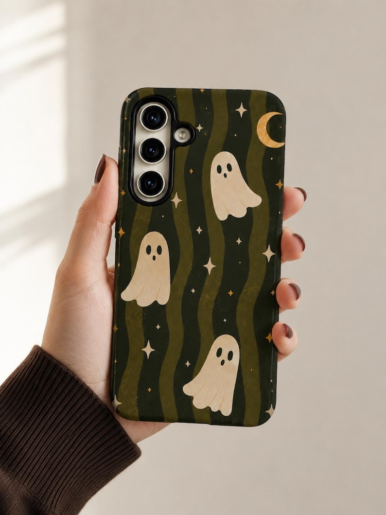 May include: A rectangular smartphone case featuring a dark green and olive wavy striped background. The design includes multiple cream-colored ghost illustrations with simple facial features, interspersed with small yellow four-pointed stars and a crescent moon.