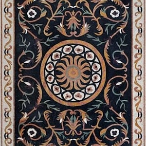 May include: A rectangular mosaic tile with a black background and an ornate floral design. The design features a central circular motif with a sunburst pattern, surrounded by swirling vines, flowers, and a decorative border in shades of gold, white, and green.