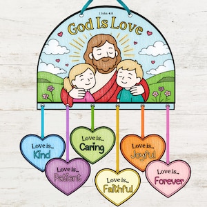 Op de afbeelding: Een kleurrijke wanddecoratie met de tekst "God Is Love" en een illustratie van Jezus met twee kinderen. Zes hartvormige ornamenten tonen "Love is... Kind, Caring, Patient, Joyful, Faithful, Forever."