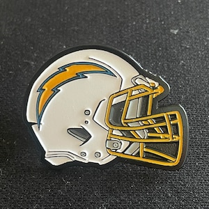 May include: A white and black football helmet with a gold facemask and a blue and yellow lightning bolt logo.