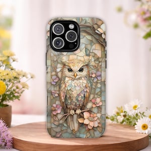 May include: A smartphone case featuring a detailed illustration of an owl perched on a branch surrounded by flowers. The design uses a mosaic-like pattern with soft pastel tones of beige, pink, and blue, covering the entire back of the phone case.