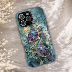 May include: A smartphone case featuring a vibrant mosaic-style design of two sea turtles swimming among starfish. The turtles have iridescent purple and blue shells, set against a background of teal and green geometric glass-like shards.
