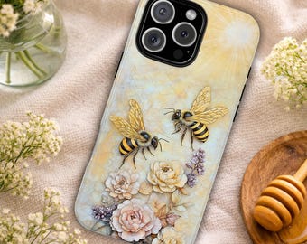 May include: A smartphone case featuring a light yellow background with a sunburst effect, two detailed honeybees, and a cluster of pale pink and cream-colored flowers. The case has a black camera cutout and a smooth, glossy finish.