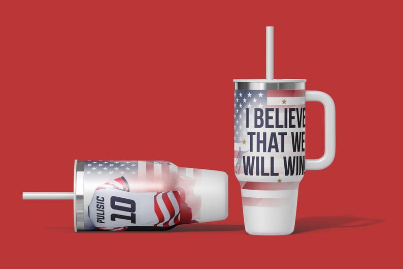 May include: Two white insulated tumblers with lids and straws. One upright, the other lying down. Both feature an American flag design and the text "I BELIEVE THAT WE WILL WIN." One tumbler displays the name "PULISIC" and the number "10."
