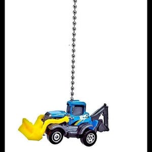 May include: A small, blue and yellow toy backhoe hangs from a silver chain against a white background. The toy has black wheels and a yellow front loader. The backhoe arm is black.