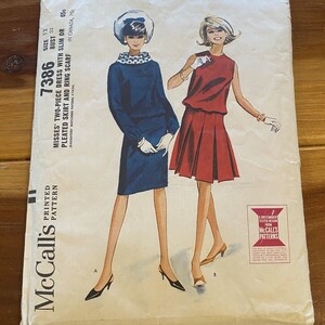 May include: Vintage McCall's sewing pattern for a two-piece dress with a pleated skirt and a ring scarf. The pattern is for sizes 12 and bust 32. The pattern is printed on a white background with a red and black border. The pattern includes a drawing of a woman wearing the dress.