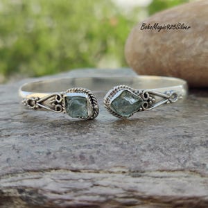 Puede incluir: Pulsera de plata con dos piedras de aguamarina azul claro. La pulsera tiene un dise&ntilde;o delicado y adornado.