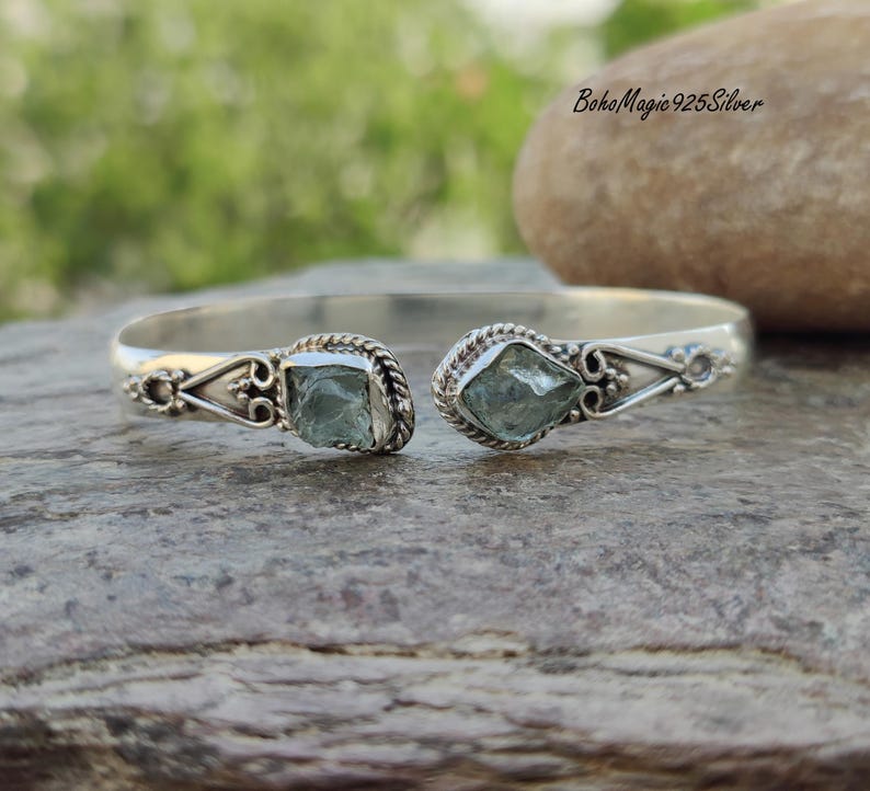 Puede incluir: Pulsera de plata con dos piedras de aguamarina azul claro. La pulsera tiene un dise&ntilde;o delicado y adornado.