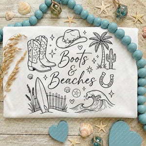 May include: White graphic tee featuring the text "Boots & Beaches" and illustrations of cowboy boots, a cowboy hat, a palm tree, a surfboard, and a horseshoe. The design is in black ink.