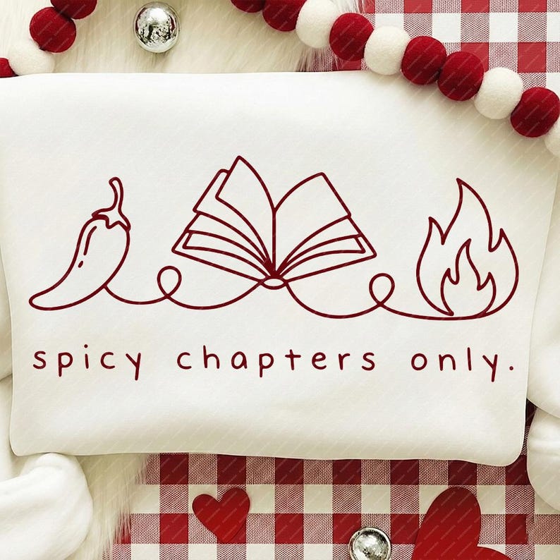 May include: White sweatshirt with a red graphic of a chili pepper, open book, and flames, connected by a line. The text "spicy chapters only" is below the graphic. The sweatshirt is on a red and white checkered surface.