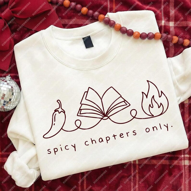 May include: White crewneck sweatshirt with a graphic design in dark red. The design features a chili pepper, an open book, and flames, connected by a line, with the text "spicy chapters only."