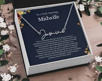 May include: A silver necklace with the name "Jasmine" spelled out in cursive script. The necklace is in a box with a blue background and a message that reads "To a Truly Amazing Midwife". The message continues with a heartfelt thank you to a midwife for their compassionate care during the journey to motherhood.
