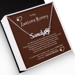 May include: A silver necklace with a paw print charm and the name "Sandy" on it. The necklace is in a brown box with a message that reads "To My Awesome Mommy". The message continues with a poem about a dog and their owner.
