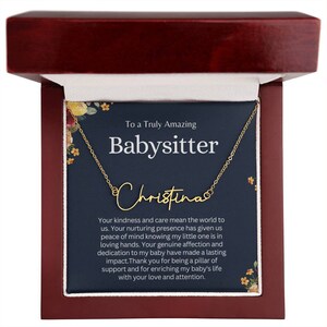 May include: A gold necklace with the name "Christina" on it, inside a wooden box with a blue card that reads "To a Truly Amazing Babysitter". The card has a floral design and a message thanking the babysitter for their kindness and care.