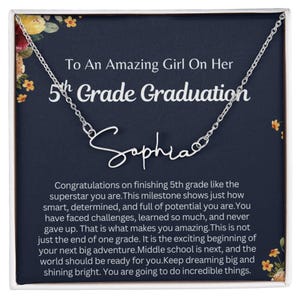 May include: A silver necklace with the name "Sophia" in cursive script. The necklace is presented on a navy blue background with the text "To An Amazing Girl On Her 5th Grade Graduation". The card includes a congratulatory message.