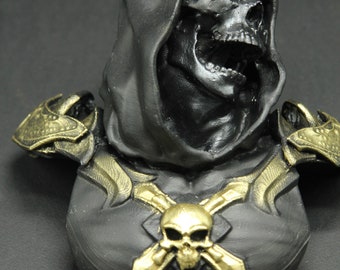 May include: Black and gold skull bust with a hooded head and a skull and crossbones design on the chest.