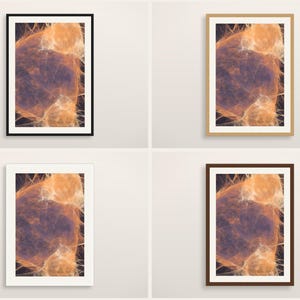 May include: Four framed wall art prints featuring an abstract design with swirling orange and purple nebulous patterns. The set includes one black frame, one light wood frame, one white frame, and one dark brown frame, all displayed in a grid.