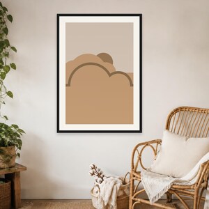 May include: A framed wall art print featuring a minimalist abstract landscape with layered shapes in shades of beige, tan, and brown. The composition includes rounded cloud-like forms and a semi-circular sun element set against a neutral background.