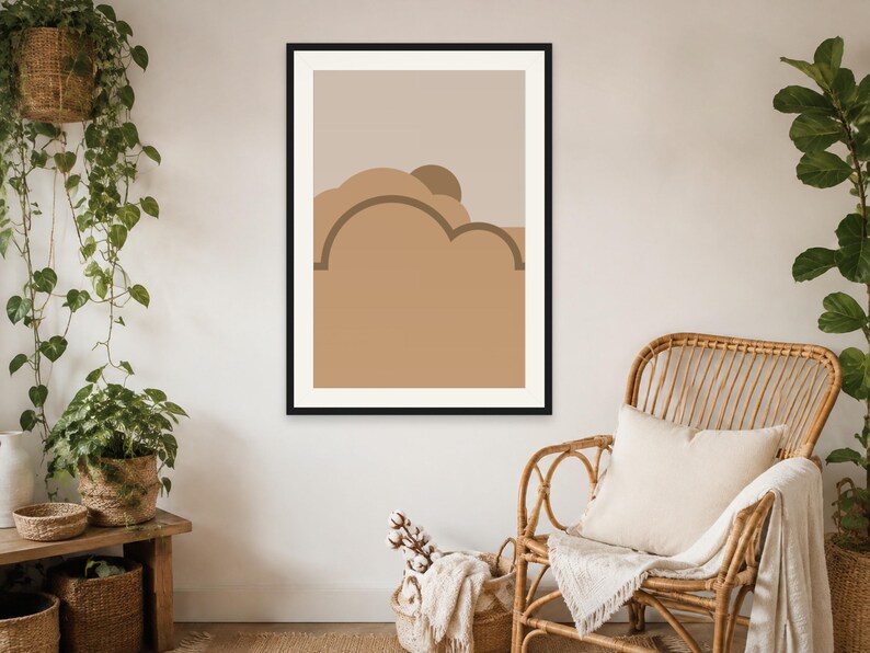 May include: A framed wall art print featuring a minimalist abstract landscape with layered shapes in shades of beige, tan, and brown. The composition includes rounded cloud-like forms and a semi-circular sun element set against a neutral background.