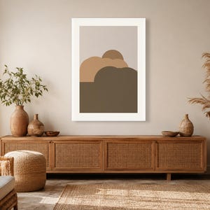 Puede incluir: Una impresi&oacute;n de arte mural rectangular que presenta una serie de formas abstractas redondeadas y superpuestas en tonos beige, canela y marr&oacute;n oscuro, sobre un fondo gris claro y dentro de un marco blanco simple y limpio.