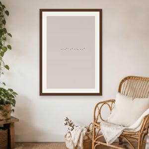 May include: A rectangular wall art print featuring a minimalist beige background with a small, centered horizontal line of tiny dark birds in flight, enclosed within a thick, dark brown wooden frame hanging on a plain wall.