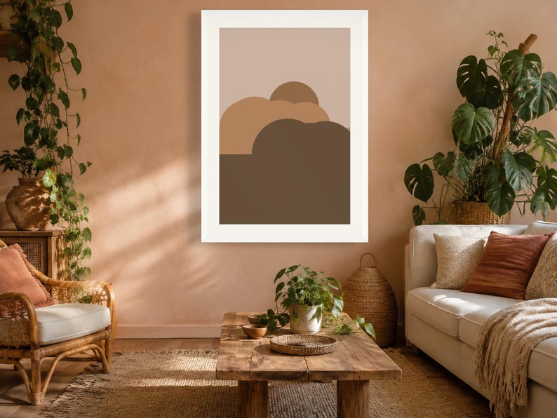 Puede incluir: Una impresi&oacute;n de arte mural rectangular que presenta un dise&ntilde;o de paisaje abstracto minimalista con formas redondeadas superpuestas en tonos beige, marr&oacute;n claro y marr&oacute;n oscuro, dentro de un marco blanco, en formato vertical.