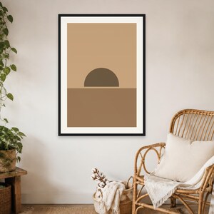 May include: A framed wall art print featuring a geometric composition with a dark brown semi-circle positioned above a solid brown horizontal band against a light tan background, enclosed within a thin black frame hanging on a plain wall.