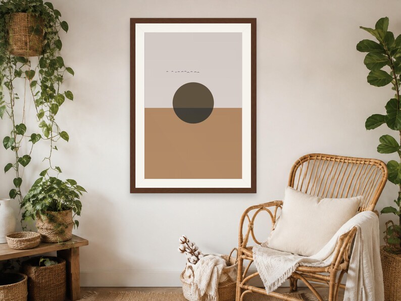 May include: A framed wall art print featuring a split-tone design with a light gray upper section and a solid tan lower section. A dark brown circle is centered over the horizontal line, and a small line of tiny black birds is visible above.