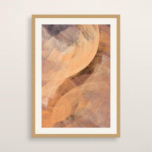 May include: A rectangular wall art print in a light wood frame featuring an abstract composition of swirling, translucent layers in shades of soft peach, warm orange, muted brown, and deep charcoal gray, creating a fluid, layered visual effect.