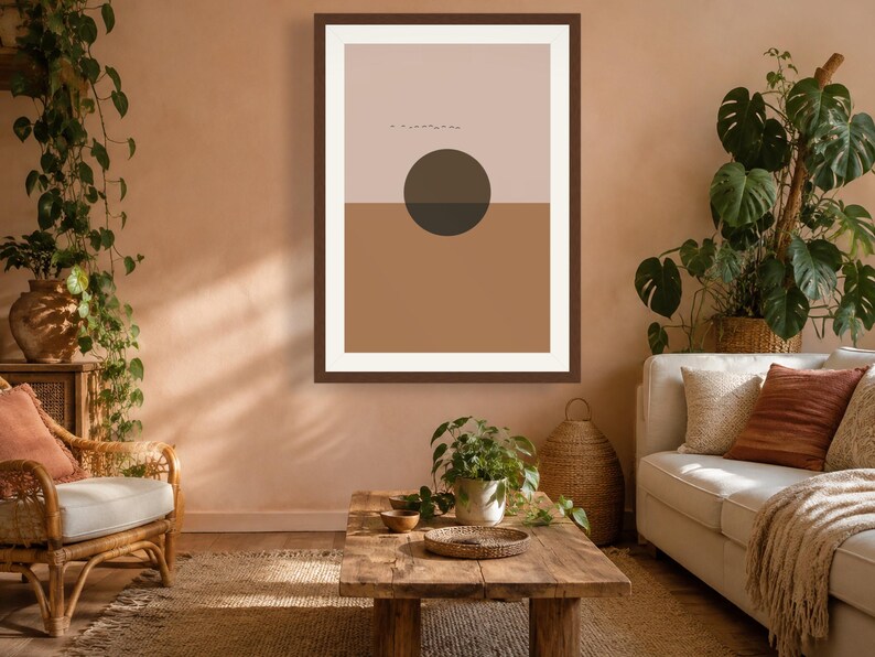 May include: A rectangular wall art print in a dark brown frame featuring a split-color design with a light beige upper half and a medium brown lower half. A dark brown circle is centered over the horizontal line, with small black line art above.