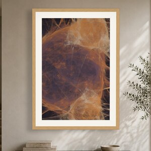 May include: A framed wall art print featuring an abstract composition of swirling, translucent orange and amber filaments set against a deep, dark purple background, enclosed within a light-toned wooden frame with a wide white mat border.