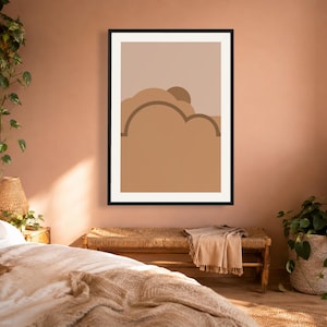 May include: A framed wall art print featuring a minimalist abstract landscape design with layered shapes in shades of tan, beige, and brown. The composition includes rounded, cloud-like forms and a semi-circular sun element set against a light background.