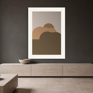 May include: A framed wall art print featuring a series of overlapping, rounded abstract shapes in varying shades of brown, tan, and beige, set against a light gray background, enclosed within a thick, solid white rectangular frame.