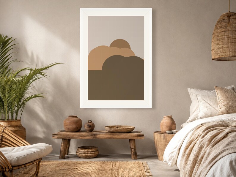 Puede incluir: Una l&aacute;mina de arte mural enmarcada que presenta una composici&oacute;n de paisaje abstracto con formas redondeadas superpuestas en tonos beige, tostado y marr&oacute;n oscuro, sobre un fondo gris claro con un borde blanco grueso.