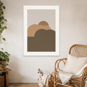 Puede incluir: Una impresi&oacute;n de arte mural rectangular que presenta una serie de formas abstractas redondeadas y superpuestas en tonos beige, tostado y marr&oacute;n oscuro, sobre un fondo gris claro y dentro de un marco blanco simple.