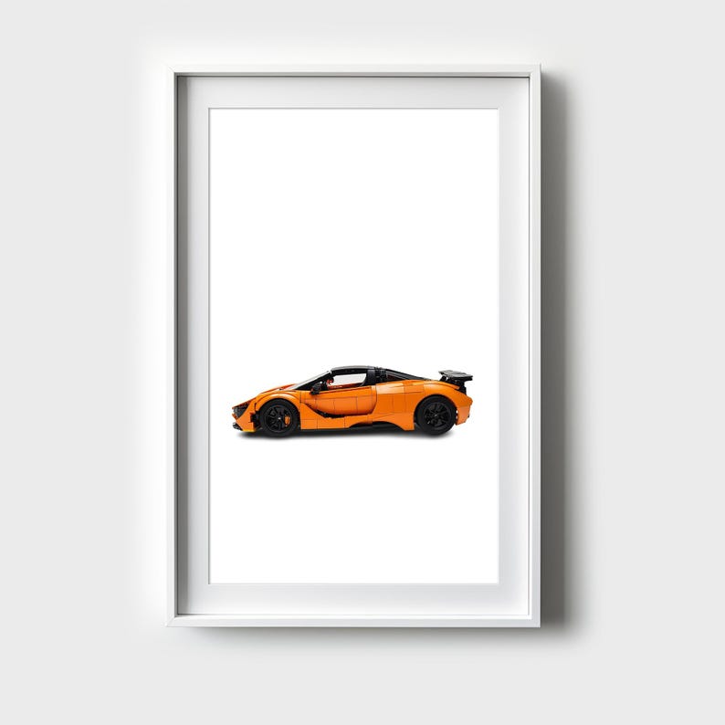 May include: A framed print of an orange sports car with a black interior and black wheels. The car is on a white background.