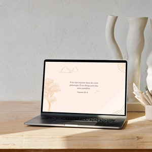 Peut inclure: Un ordinateur portable avec un fond rose clair et une citation en police marron clair. La citation dit "S'il me fait reposer dans de verts pâturages, Il me dirige près des eaux paisibles." Psaume 23:2.