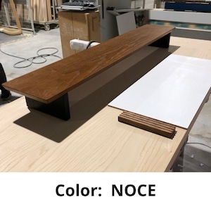 May include: A wooden shelf with black metal brackets. The shelf is made of wood with a noce finish. The shelf is sitting on a light wood surface. Color: NOCE