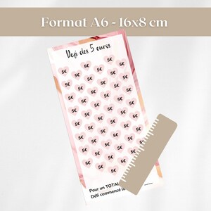 Pu&ograve; includere: Scheda formato A6 con il testo "Defi des 5 euros". La scheda presenta forme di cuore rosa con "5&euro;" all'interno. Un righello &egrave; posto sul lato. La scheda misura circa 16 x 8 cm.