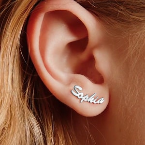 May include: Silver earrings with the name "Sophia" spelled out in a cursive font.