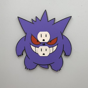 May include: Purple and black cartoon Gengar wall plate with two white electrical outlets.