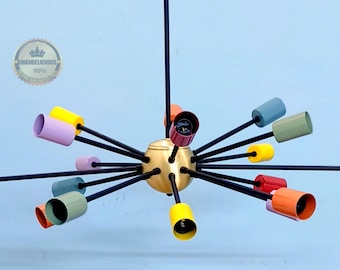 May include: A modern, multi-light chandelier with a gold centre and black arms. The light shades are colourful and include red, orange, yellow, green, blue, and purple.