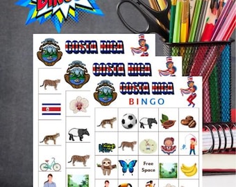 May include: Two Costa Rica Bingo game cards with colorful illustrations of Costa Rican symbols, animals, and people. The word "BINGO" is displayed in a comic book style burst. Pencils, scissors, and a ruler are in the background.