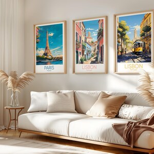 May include: Three framed vertical art prints hanging on a wall. The left print shows the Eiffel Tower in Paris, France. The middle print depicts a narrow street in Lisbon, Portugal. The right print features a yellow tram in a Lisbon street scene.