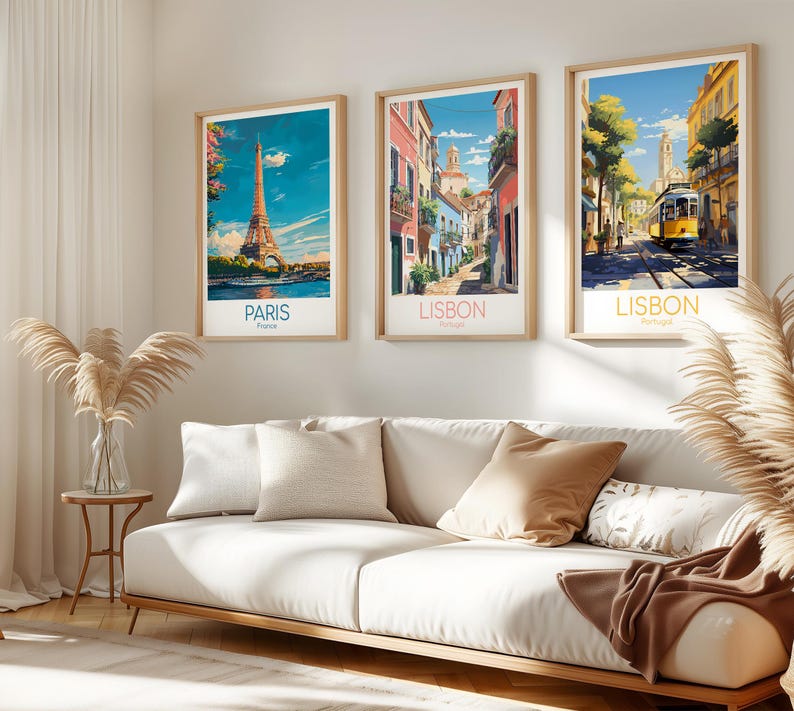 May include: Three framed vertical art prints hanging on a wall. The left print shows the Eiffel Tower in Paris, France. The middle print depicts a narrow street in Lisbon, Portugal. The right print features a yellow tram in a Lisbon street scene.
