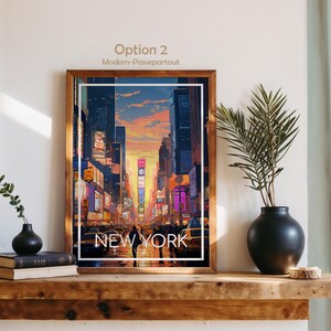 May include: A framed vertical art print featuring a stylized illustration of a New York City street scene at sunset with tall buildings, glowing billboards, and yellow taxis. The text NEW YORK USA is printed in white at the bottom of the image.