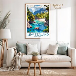 Puede incluir: Una impresi&oacute;n de arte mural vertical enmarcada con una ilustraci&oacute;n de paisaje de Nueva Zelanda con monta&ntilde;as nevadas, un puente colgante y un r&iacute;o turquesa. El texto NEW ZEALAND y Pacific Ocean est&aacute; impreso en azul en la parte inferior.
